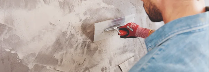 Person verputzt Wand